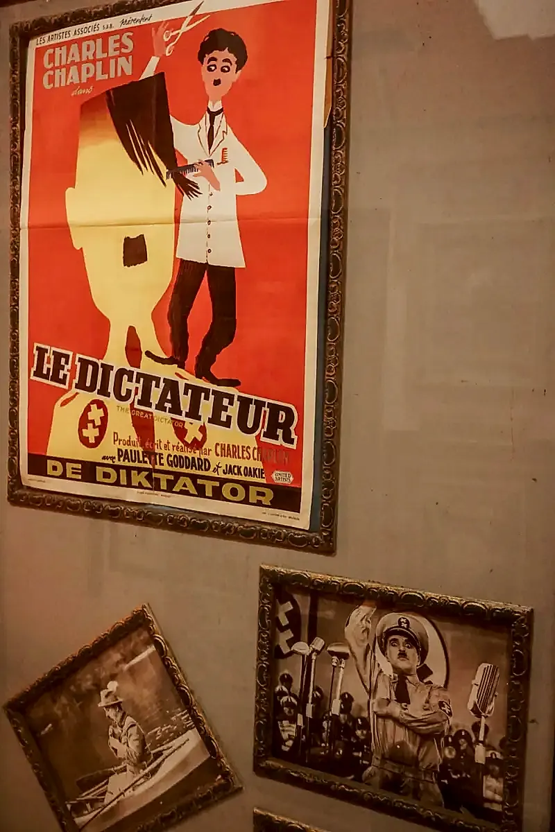 A poster with French text and two lobby cards advertising the film The Great Dictator (1940). The former features a cartoon of the film's star Charles Chaplin.
