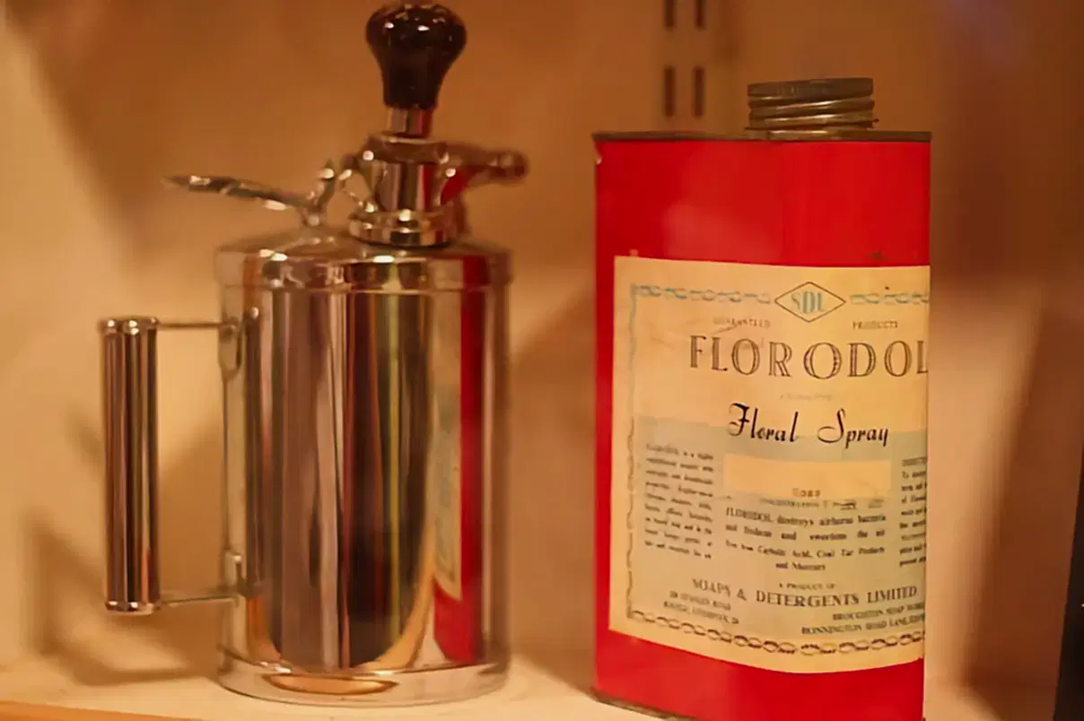 A can of liquid, labelled 'Florodol Floral Spray', next to a device for spraying it as an air freshener.