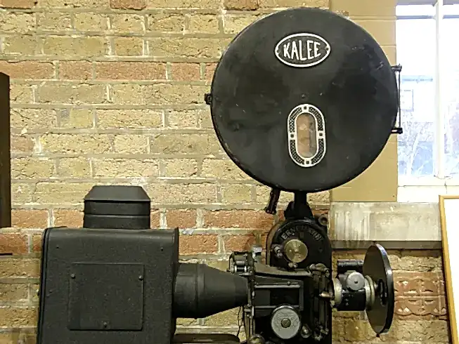 A vintage cinema projector with a badge reading 'Kalee' featured prominently.