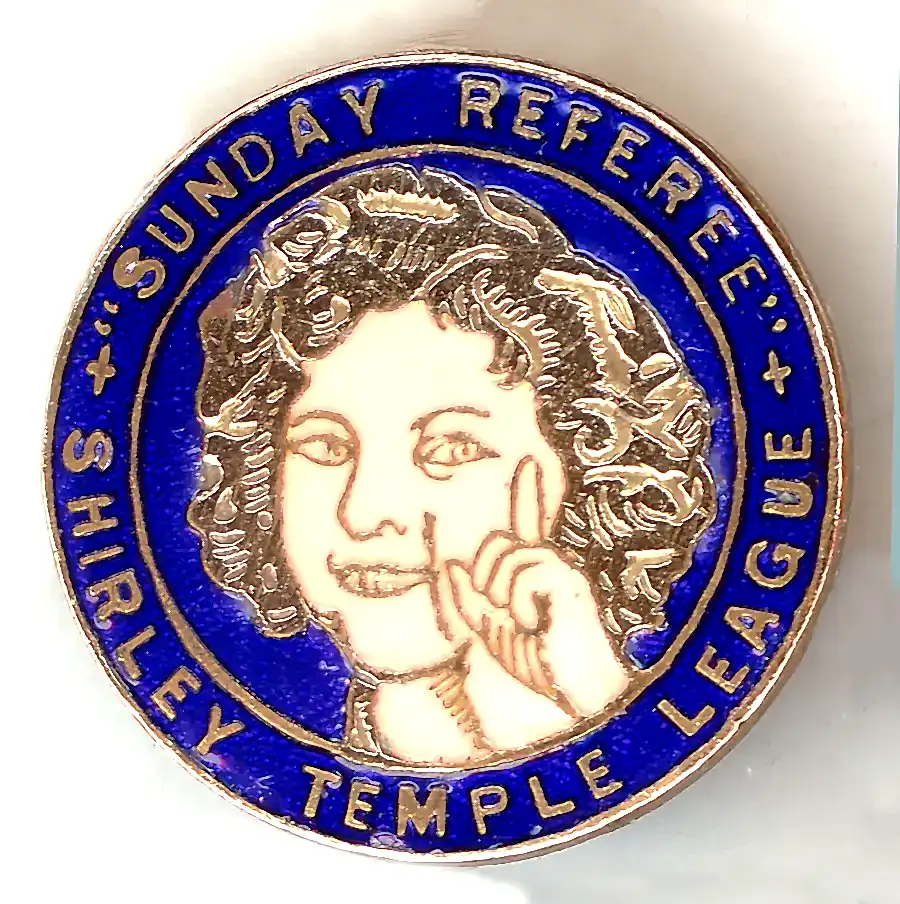 A blue enamel circular badge with picture of Shirley Temple at the centre. Around the edge it reads: "Sunday Referee - Shirley Temple League".