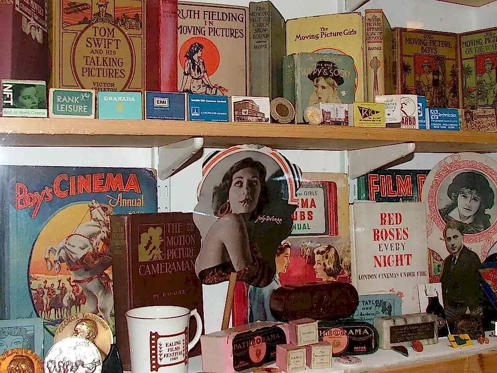 Cinema books and other artefacts displayed on two shelves in a glass case.