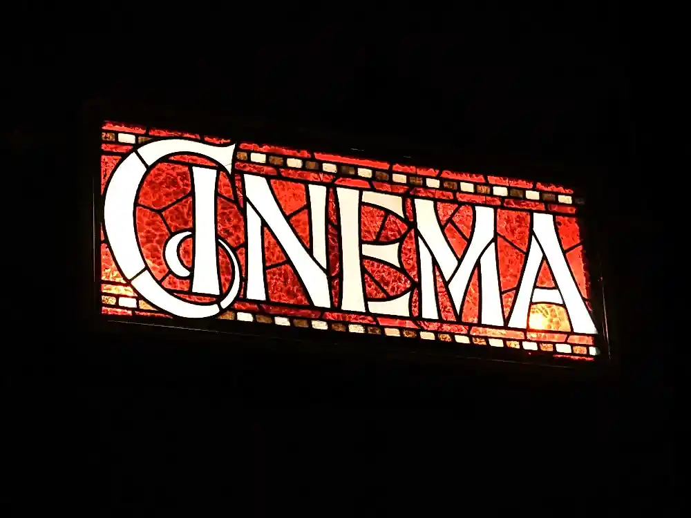 An illuminated sign in the style of stained glass and reading 'Cinema'.
