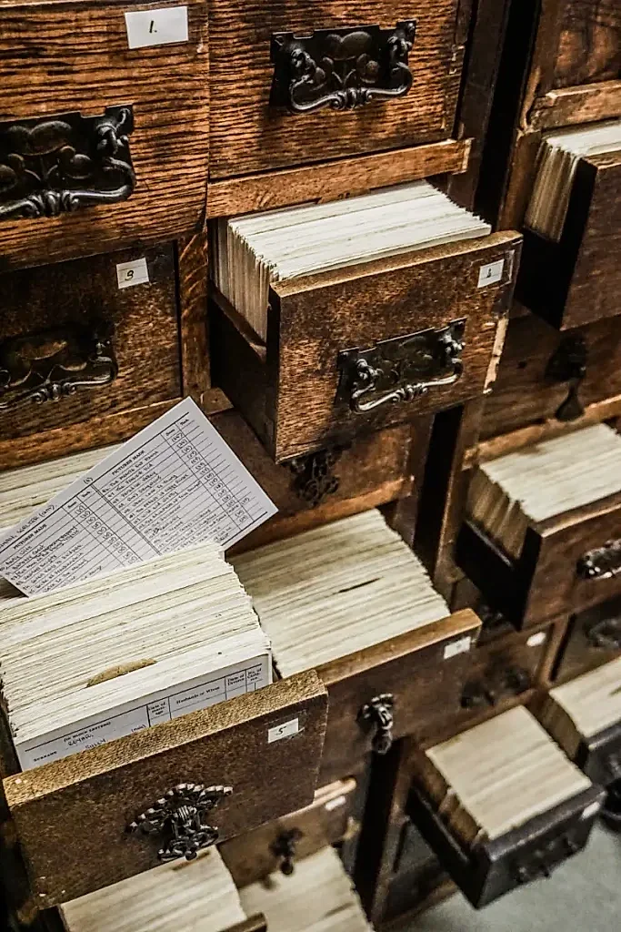 Small wooden draws; some are open, revealing a large number of index cards.
