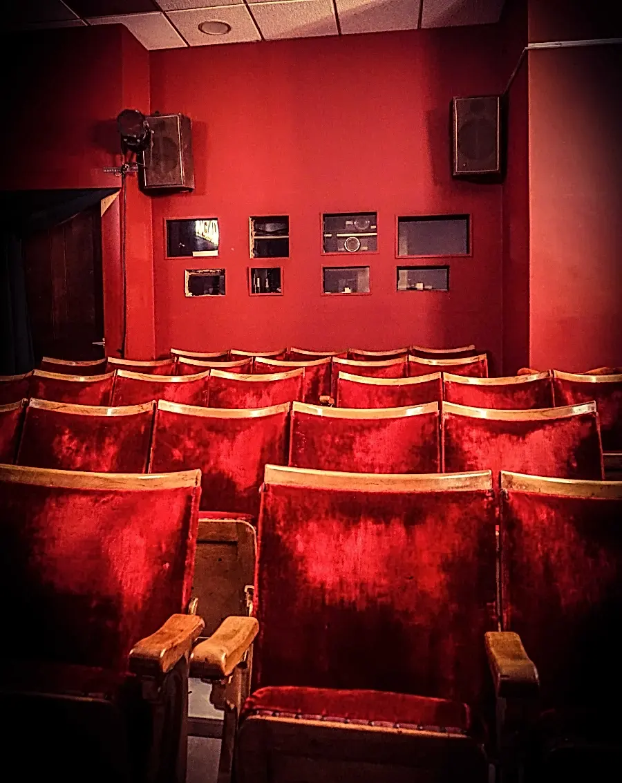 A view of the cinema seating and windows into the projection booth in the screening room.